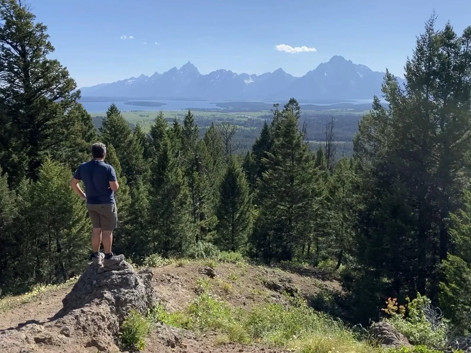 Keno Vigil looking out over a mountain range from a trail overlook