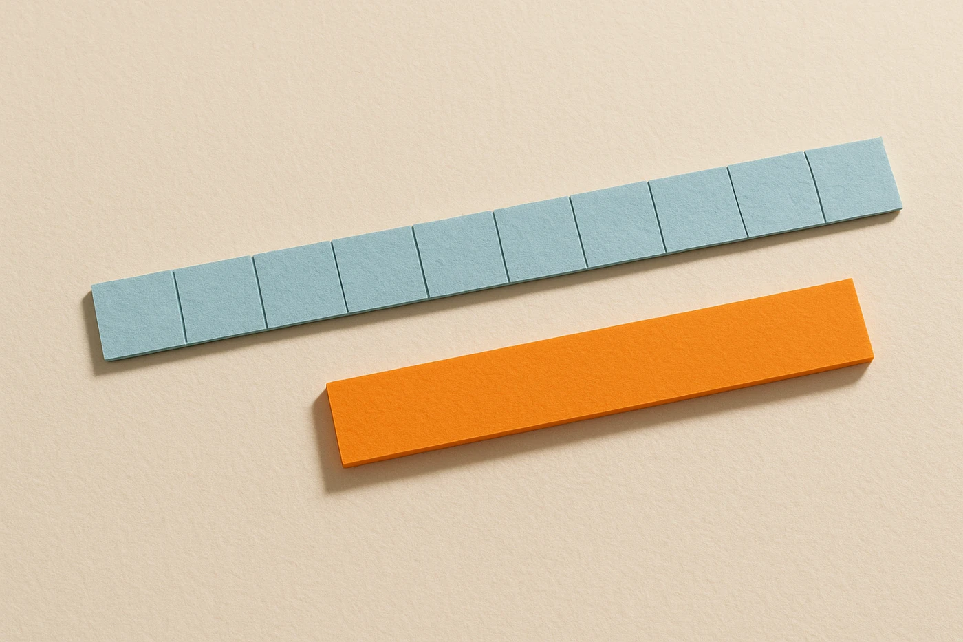 Cut-paper illustration of a long chain of small pale blue tiles laid end to end, beside one solid orange tile of the same length formed as a single uncut piece