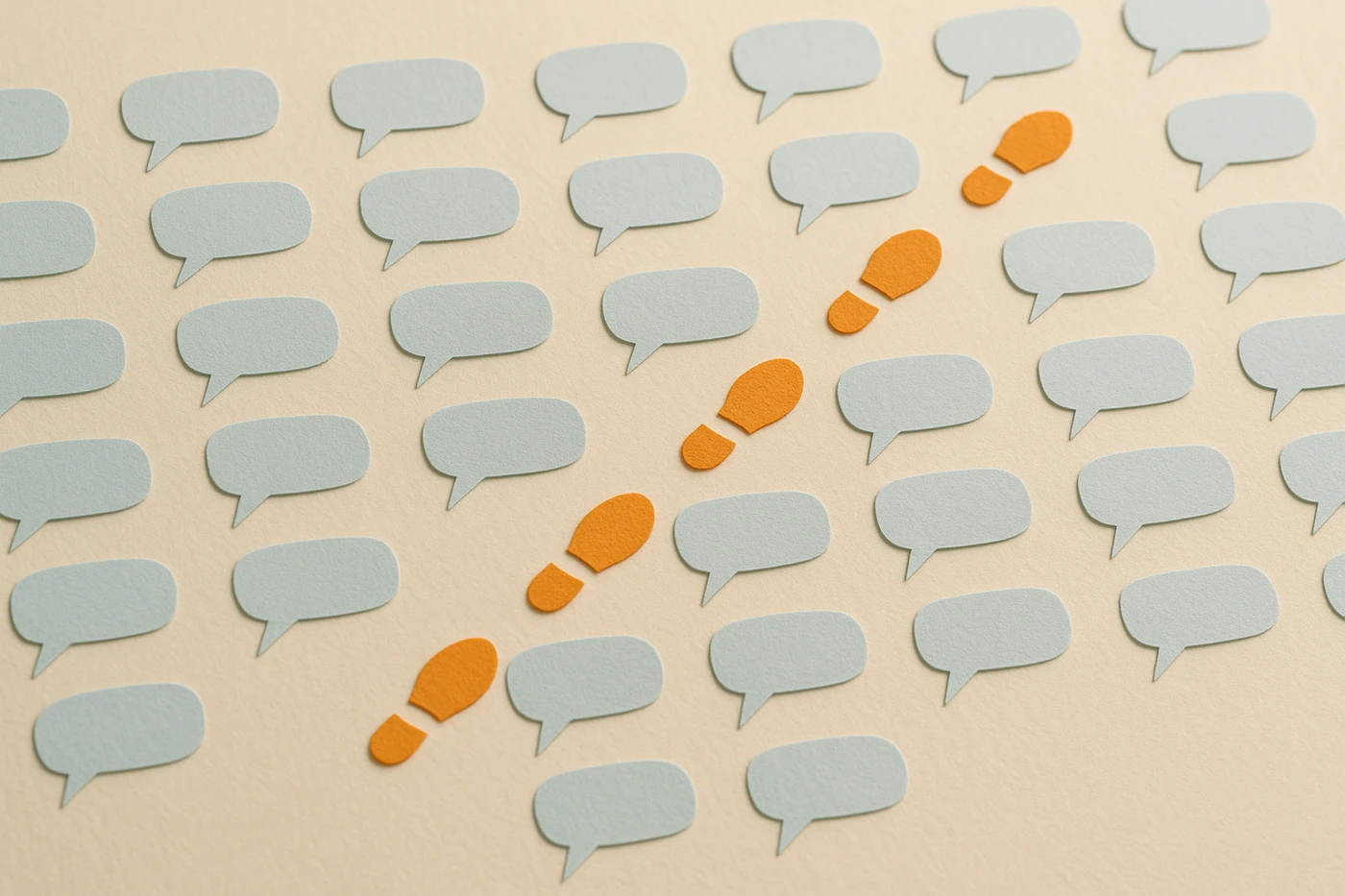 Cut-paper illustration of a pale blue field of dozens of identical paper speech bubbles all angled the same way across an ivory ground, with one orange trail of footprints cutting across them in a different direction entirely